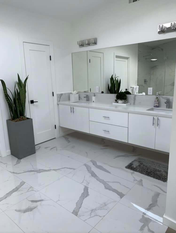 Spotless marble bathroom with gleaming floors and white vanity