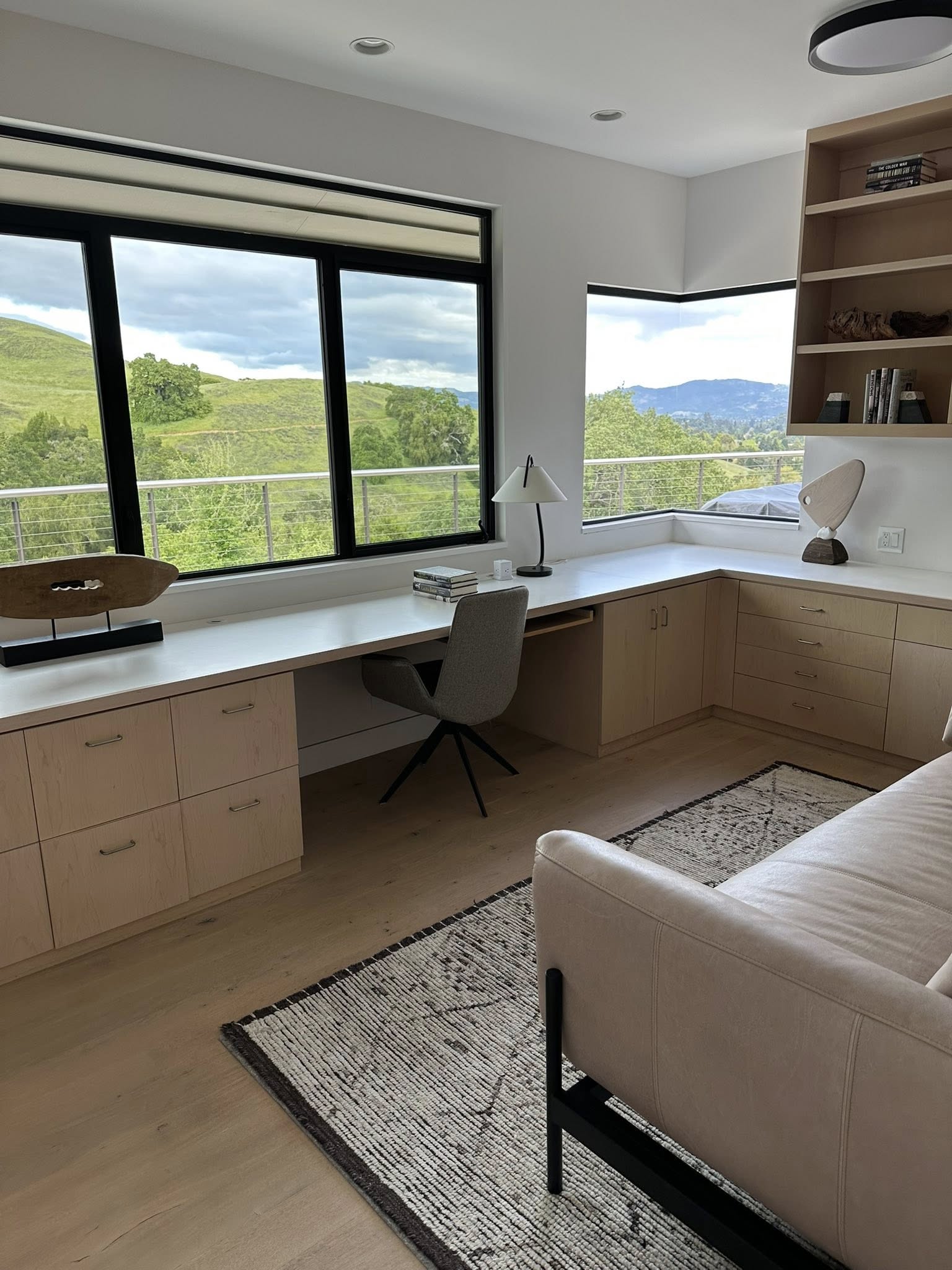 Bright home office with green hills visible through large windows